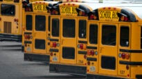 Fairfax County Public School buses are lined up at a maintenance facility
