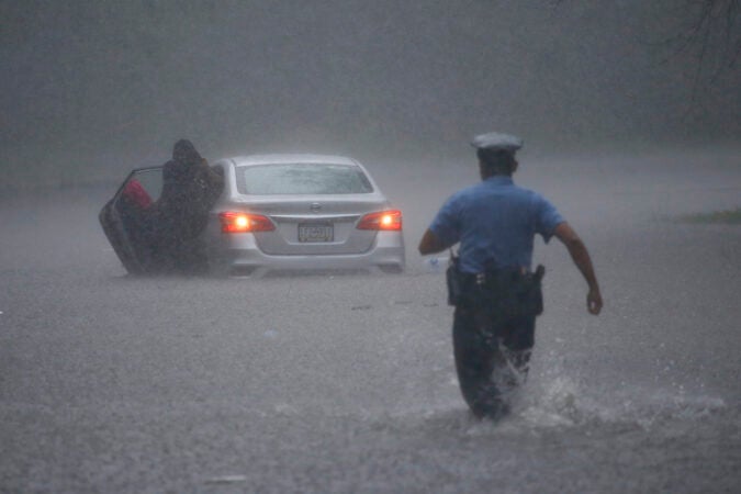 A Philadelphia police officer rushes to help a stranded motorist during Tropical Storm Isaias