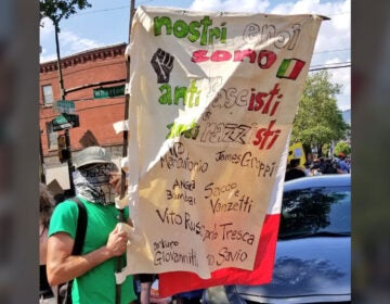 A protester carries a sign in Italian that reads 