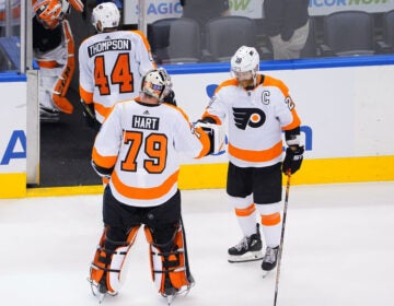 Carter Hart celebrates with captain Claude Giroux