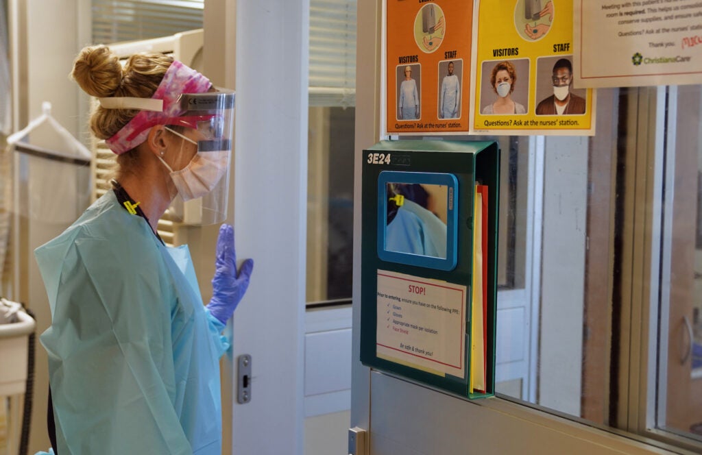 A registered nurse prepares to enter a COVID-19 patient's room