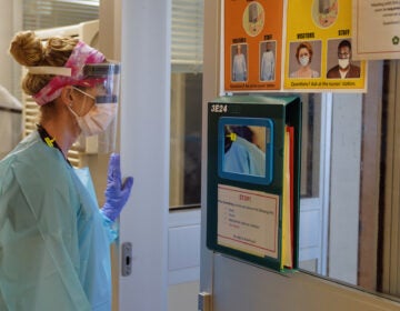 A registered nurse prepares to enter a COVID-19 patient's room