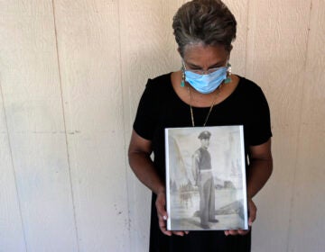 Belvin Jefferson White poses with a portrait of her father Saymon Jefferson, who died from COVID-19, in Baton Rouge, La., in May. (Gerald Herbert/AP)