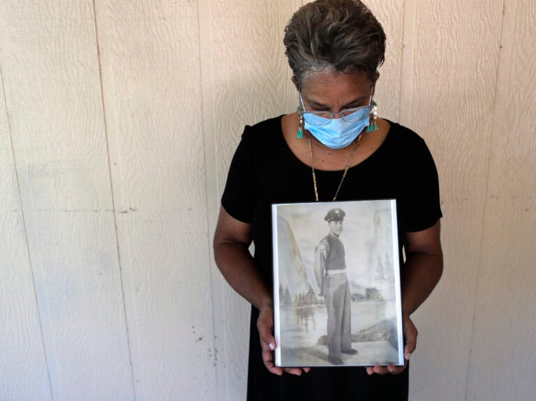 Belvin Jefferson White poses with a portrait of her father Saymon Jefferson, who died from COVID-19, in Baton Rouge, La., in May. Belvin Jefferson White poses with a portrait of her father Saymon Jefferson, who died from COVID-19, in Baton Rouge, La., in May. (Gerald Herbert/AP)