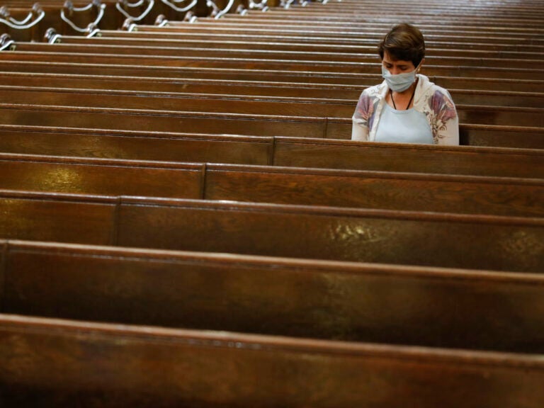 A parishioner sits after Mass last month at a Catholic church in New York City. An overwhelming majority of U.S. adults believe that houses of worship should be subject to the same restrictions on public gatherings that apply to other institutions. (John Minchillo/AP Photo)