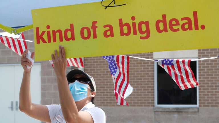 U.S. Census Bureau worker Marisela Gonzales adjusts a sign at a walk-up counting site for the 2020 census in Greenville, Texas, in July. (LM Otero/AP Photo)