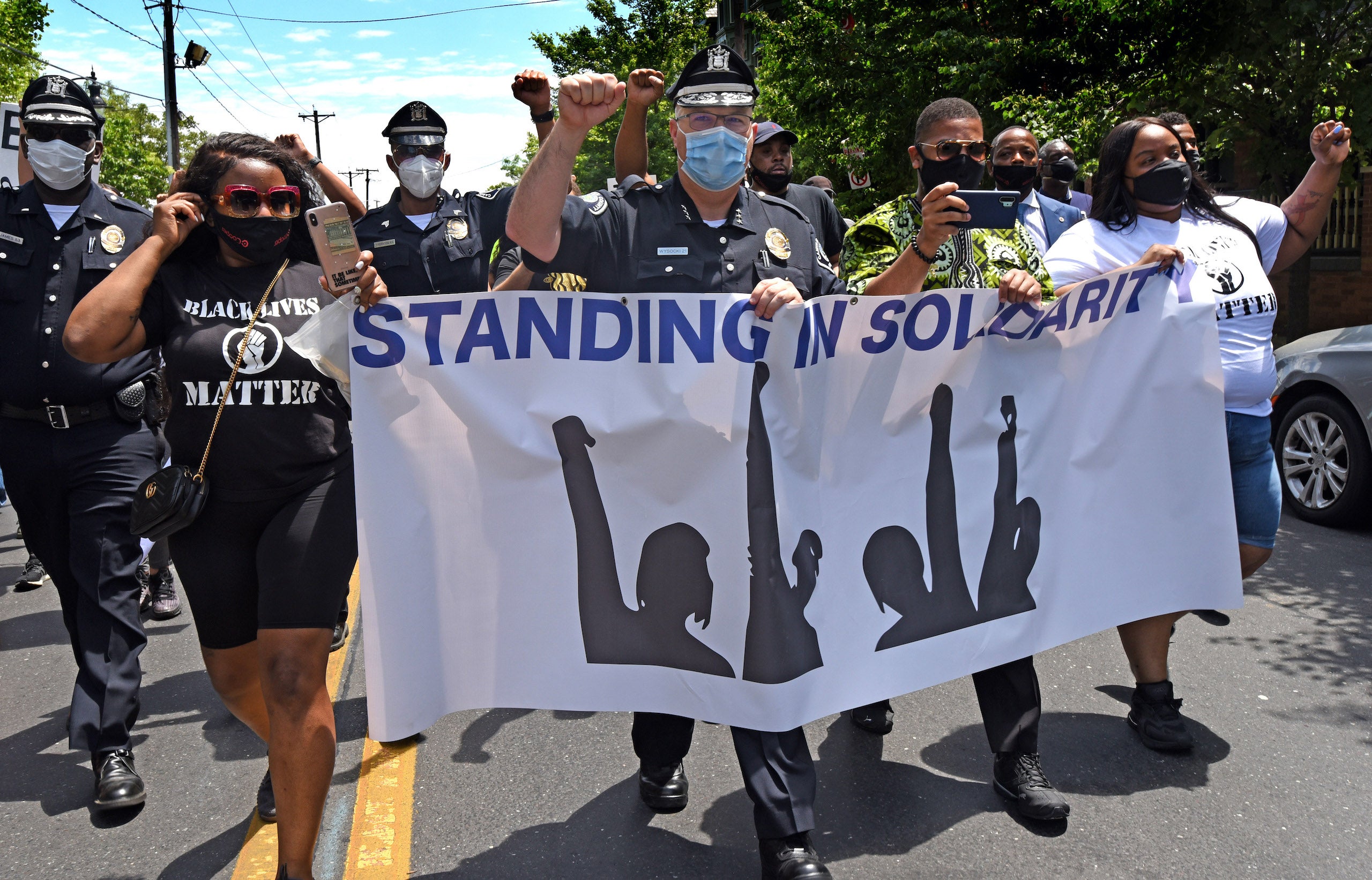 Camden County Police Chief Joe Wysocki raises a fist while marching with Camden residents