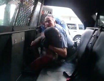 Minneapolis officer Derek Chauvin is seen struggling to force George Floyd into the back seat of a police SUV, in newly released body camera video recorded by officer Tou Thao. Both Chauvin and Thao were fired, along with two other officers involved in Floyd's death on Memorial Day. All four former officers are facing charges. (Hennepin County/MPR/YouTube/Screenshot by NPR )