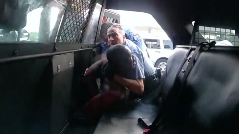 Minneapolis officer Derek Chauvin is seen struggling to force George Floyd into the back seat of a police SUV, in newly released body camera video recorded by officer Tou Thao. Both Chauvin and Thao were fired, along with two other officers involved in Floyd's death on Memorial Day. All four former officers are facing charges. (Hennepin County/MPR/YouTube/Screenshot by NPR )