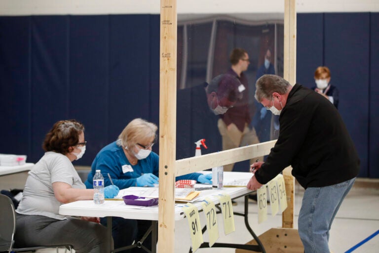 A man checks to cast his ballot in Kenosha, Wis., on April 7. A new study suggests that in-person voting in that Wisconsin primary did not produce a surge of new coronavirus cases. (Kamil Krzaczynski /AFP via Getty Images)