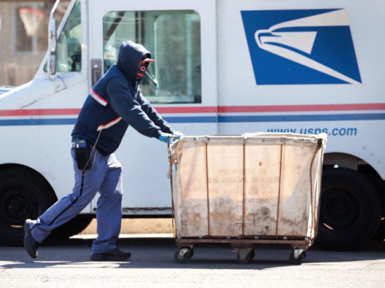 Postal workers prepare mail for delivery