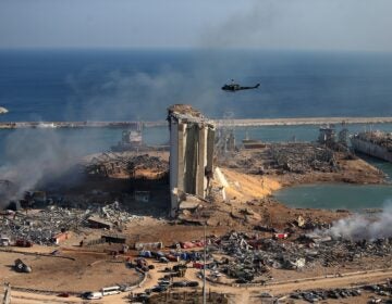 A helicopter hovers over damaged grain silos in Beirut's port on Wednesday, one day after a powerful explosion tore through Lebanon's capital.