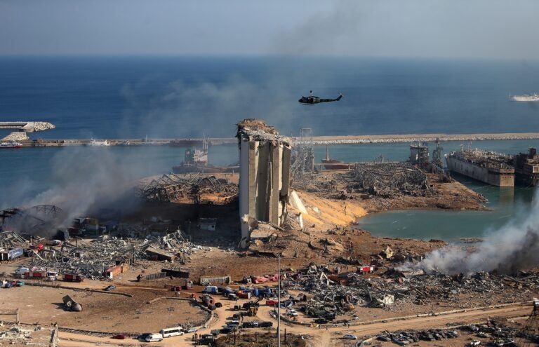 A helicopter hovers over damaged grain silos in Beirut's port on Wednesday, one day after a powerful explosion tore through Lebanon's capital.