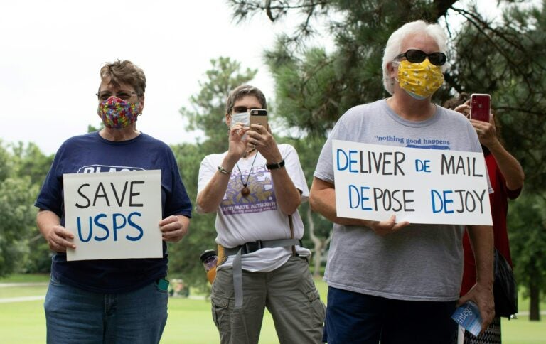 A group of protesters demonstrate in front of Postmaster General Louis DeJoy's home in Greensboro, N.C., on Sunday.