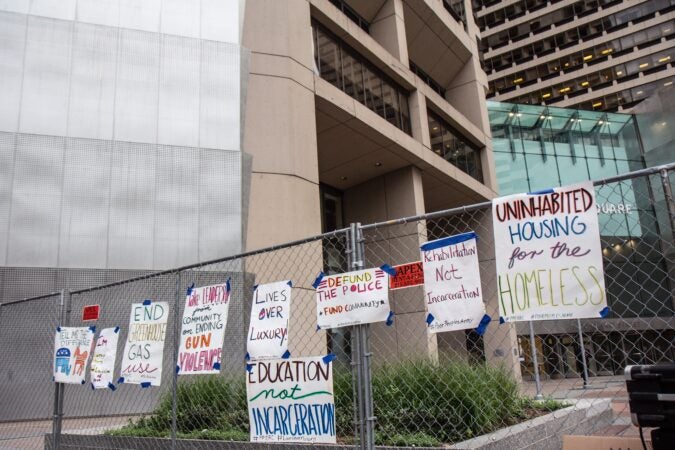 Protesters taped signs to the fence surrounding the office building of Joe Biden’s campaign headquarters