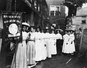 Nannie Helen Burroughs holds a banner reading, 