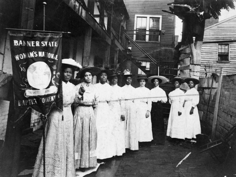 Nannie Helen Burroughs holds a banner reading, 