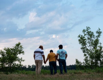 Honduran migrants, Ricardo Sr., (left), his son Ricardo Jr., 13, and his cousin Jorge, 16, walk near their home in Texas. When the two teenage boys crossed the border illegally into Texas last month, they turned themselves into Border Patrol. They were later escorted to a hotel by armed men in civilian clothes. (Scott Dalton for NPR)