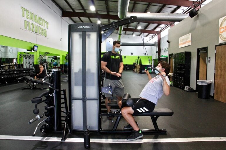 Mason Merrill of Westampton (right), works out with trainer Angelo Prince at Tenacity Fitness in Hainesport, N.J. (Emma Lee/WHYY)