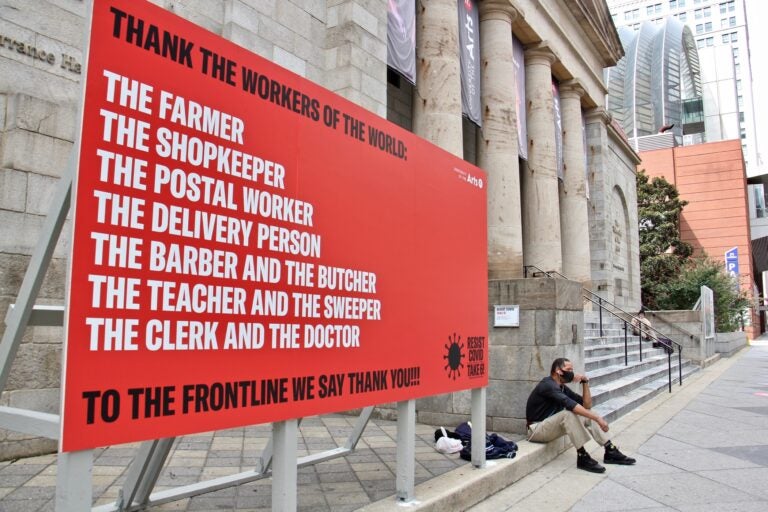 Two billboards set up outside Hamilton Hall at the University of the Arts are part of an outdoor art exhibit that draws attention to the disproportionate impact of COVID-19 on people of color. (Emma Lee/WHYY)