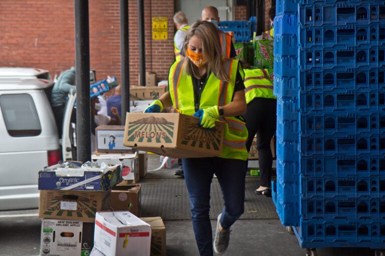 Jane Clements-Smith, executive director of Feeding PA, helps load trucks at Philabundance’s South Philly location. (Kimberly Paynter/WHYY)