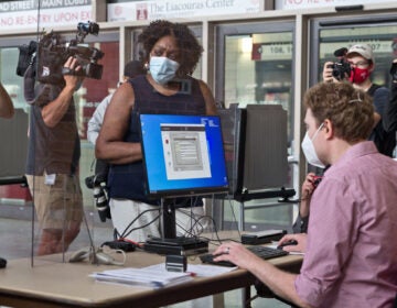 The first voter at the Liacouras Center satellite election office, Priscilla Bennett, first requests a ballot, which will be printed at the office. (Kimberly Paynter/WHYY)