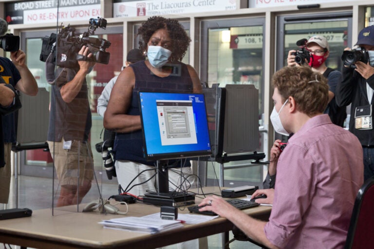 The first voter at the Liacouras Center satellite election office, Priscilla Bennett, first requests a ballot, which will be printed at the office. (Kimberly Paynter/WHYY)