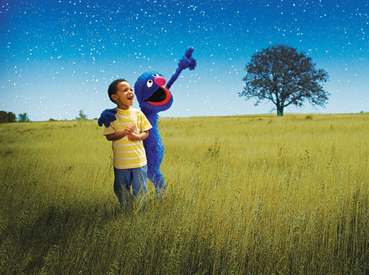 A child with Elmo under a starry night sky