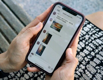 Sha Zhu, of Washington, shows the app WeChat on her phone, which she uses to keep in touch with family and friends in the U.S. and China, Tuesday Aug. 18, 2020, in Washington. (AP Photo/Jacquelyn Martin)