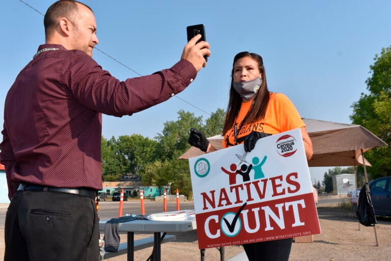 Activist Lauri Dawn Kindness, right, speaks at the Crow Indian Reservation, in Lodge Grass, Mont. on Wednesday, Aug. 26, 2020, as Lodge Grass Mayor Quincy Dabney records her for a social media campaign to increase Native American participation in the U.S. census. (AP Photo/Matthew Brown)