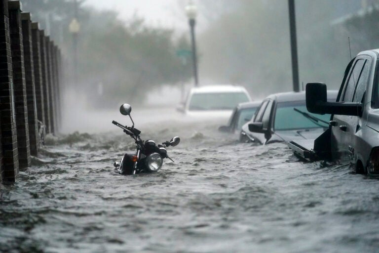 Floodwaters move on the street, Wednesday, Sept. 16, 2020, in Pensacola, Fla. Hurricane Sally made landfall Wednesday near Gulf Shores, Alabama, as a Category 2 storm, pushing a surge of ocean water onto the coast and dumping torrential rain that forecasters said would cause dangerous flooding from the Florida Panhandle to Mississippi and well inland in the days ahead.(AP Photo/Gerald Herbert)