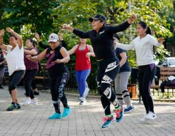 Yeni Salazar, center, leads a Zumba class in Queen's Elmhurst Memorial Park, Monday, Sept. 21, 2020 in New York. Salazar has been leading the morning outdoor classes since May because the COVID-19 pandemic has closed her health club. (AP Photo/Mark Lennihan)