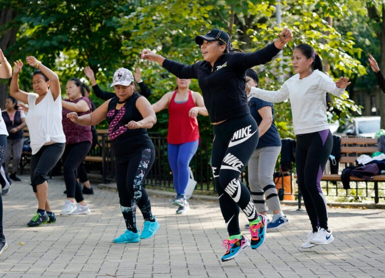 Yeni Salazar, center, leads a Zumba class in Queen's Elmhurst Memorial Park, Monday, Sept. 21, 2020 in New York. Salazar has been leading the morning outdoor classes since May because the COVID-19 pandemic has closed her health club. (AP Photo/Mark Lennihan)