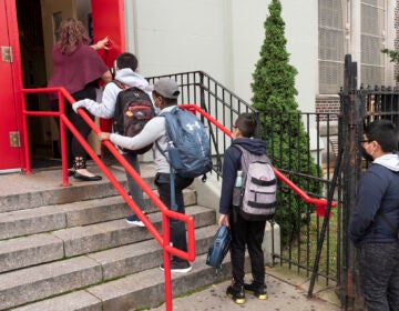 A teacher leads her students into PS 179 elementary school