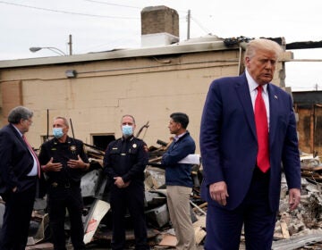 President Donald Trump turns around after talking with law enforcement officials Tuesday, Sept. 1, 2020, as he tours an area damaged during demonstrations after a police officer shot Jacob Blake in Kenosha, Wis. At left, Attorney General William Barr and acting Homeland Security Secretary Chad Wolf talk with police officers. (AP Photo/Evan Vucci)