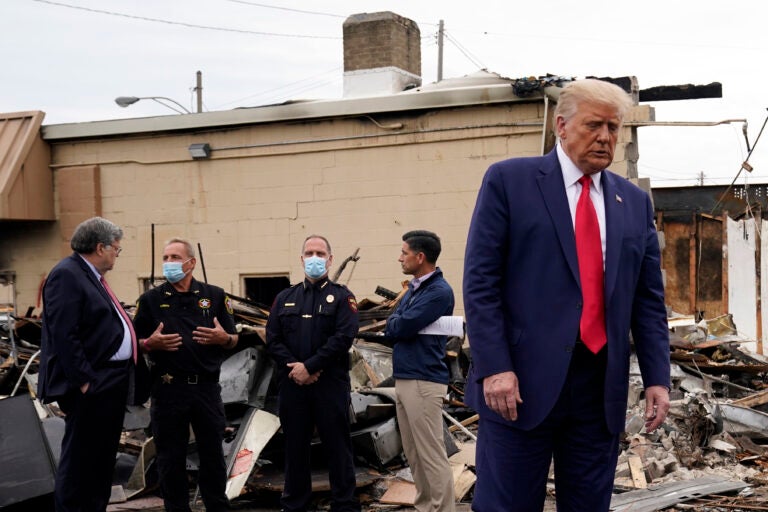 President Donald Trump turns around after talking with law enforcement officials Tuesday, Sept. 1, 2020, as he tours an area damaged during demonstrations after a police officer shot Jacob Blake in Kenosha, Wis. At left, Attorney General William Barr and acting Homeland Security Secretary Chad Wolf talk with police officers. (AP Photo/Evan Vucci)