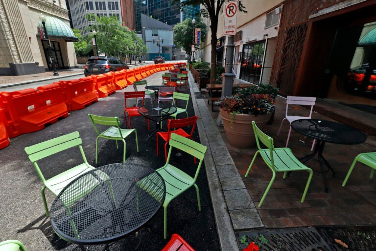 Orange barriers enclose chairs and tables that will be used for dining along Sixth Street between Liberty and Penn avenues