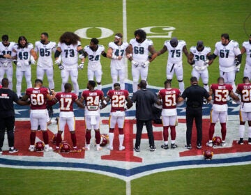 Eagles and Washington players link arms in a show of unity