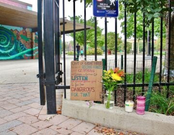 A memorial to five people shot on a basketball court, two fatally, stands at the entrance to Roberto Clemente Playground. (Emma Lee/WHYY)