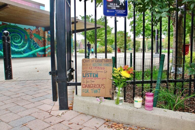 A memorial to five people shot on a basketball court, two fatally, stands at the entrance to Roberto Clemente Playground. (Emma Lee/WHYY)