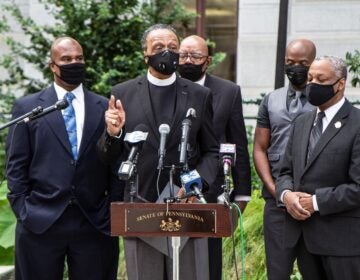 Reverend Robert Collier, president of the Philadelphia Black Clergy (center), urged voters to vote as early as they can. (Kimberly Paynter/WHYY)