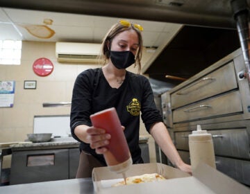 Jessica Symes, a senior at Kutztown University, works on a pizza order at Mamma's Delight Pizza Restaurant in Kutztown, Pennsylvania. (Matt Smith for Keystone Crossroads)