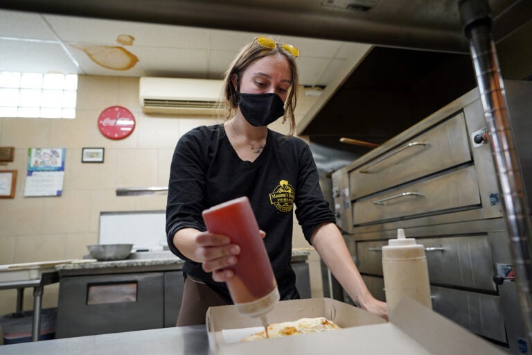 Jessica Symes, a senior at Kutztown University, works on a pizza order at Mamma's Delight Pizza Restaurant in Kutztown, Pennsylvania. (Matt Smith for Keystone Crossroads)