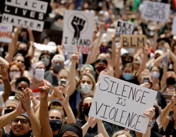 In this June 5 photo, demonstrators in downtown Kansas City, Mo., hold signs during a rally to protest the death of George Floyd. President Trump has ordered the federal government to stop critical race theory trainings. (Charlie Riedel/AP Photo)