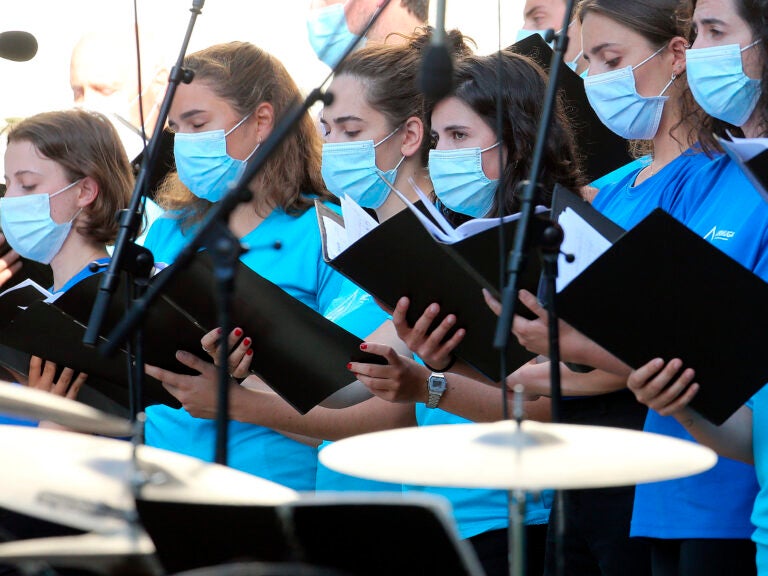 The Centers for Disease Control and Prevention briefly posted new guidance to its website stating that the coronavirus can commonly be transmitted through aerosol particles, which can be produced by activities like singing. Here, choristers wear face masks during a music festival in southwestern France in July. (Bob Edme/AP)