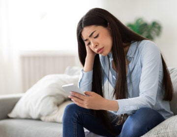 A young women looking upset at her phone