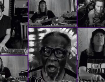 A black and white screenshot of musicians performing a song virtually through Zoom