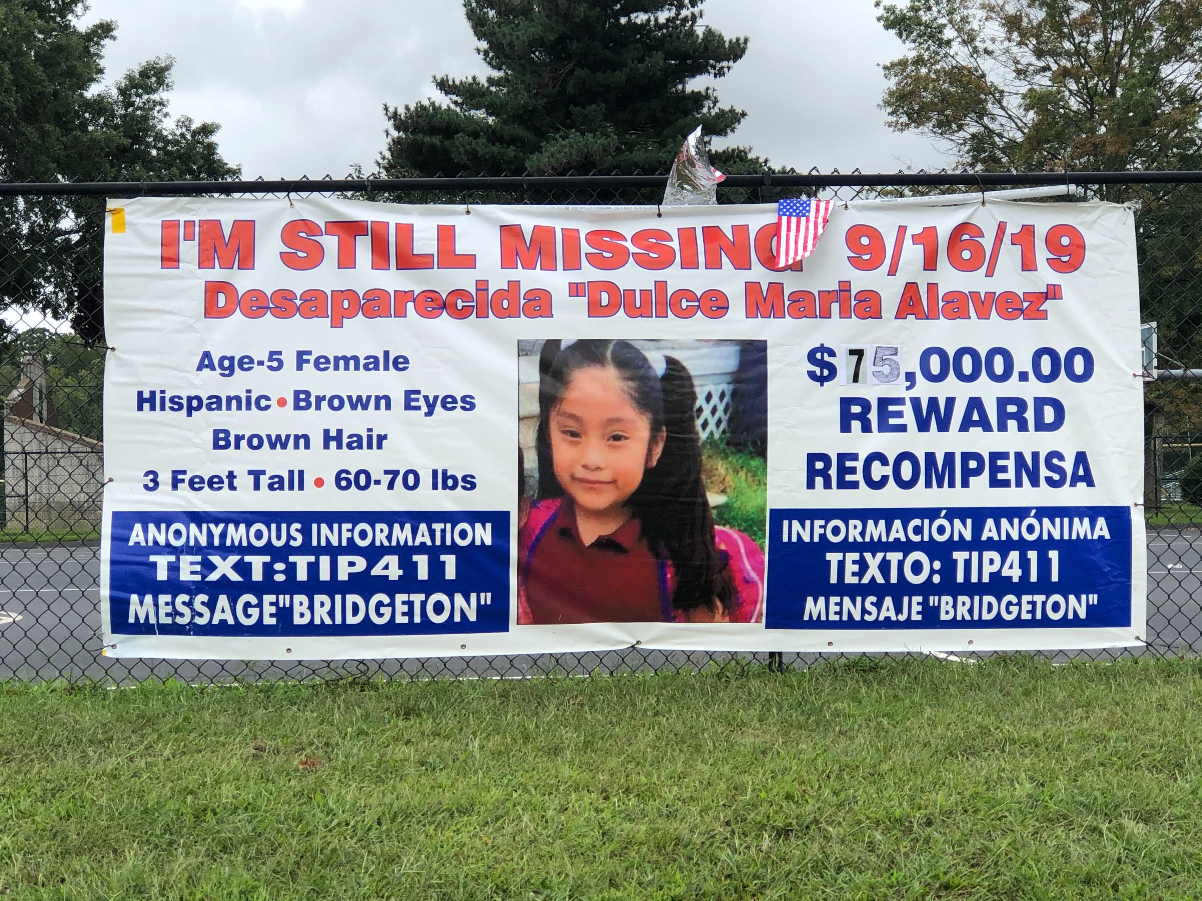 A banner with information on the reward and where to send tips via text in Bridgeton City Park hangs on a fence