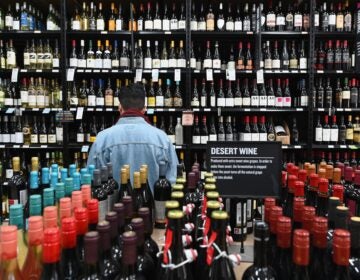 A patron stands in front of a shelf full of wine bottles at a liquor story in the Brooklyn borough of New York City on March 20. (Angela Weiss/AFP via Getty Images)