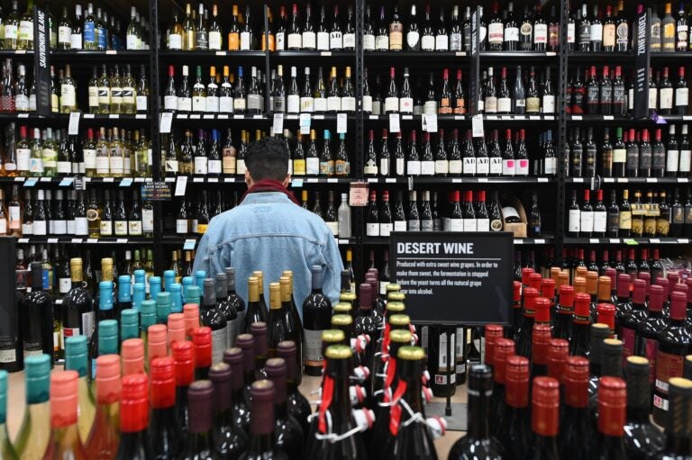 A patron stands in front of a shelf full of wine bottles at a liquor story in the Brooklyn borough of New York City on March 20. (Angela Weiss/AFP via Getty Images)